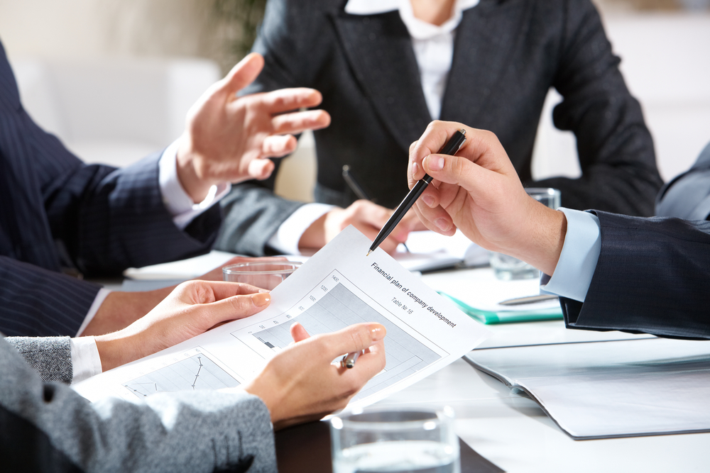 Close-up of businessman explaining a financial plan to colleagues at meeting